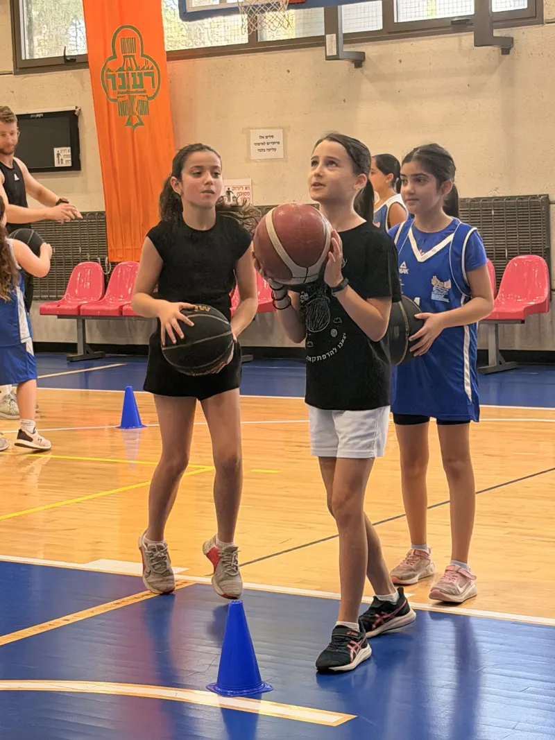 ילדות עומדות עם כדורי כדורסל ומתכוננות לתרגול